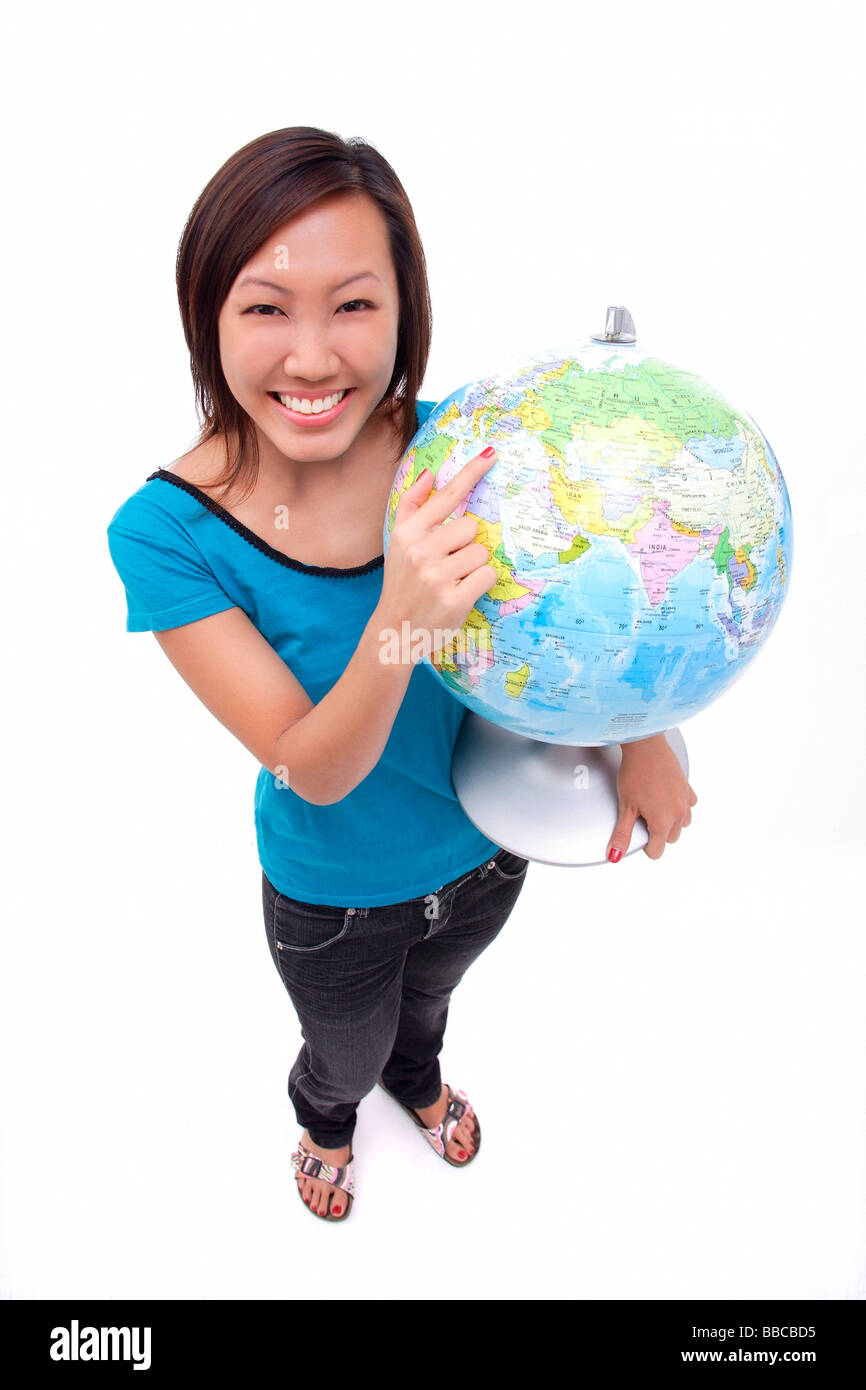 Woman holding globe, smiling at camera Banque D'Images