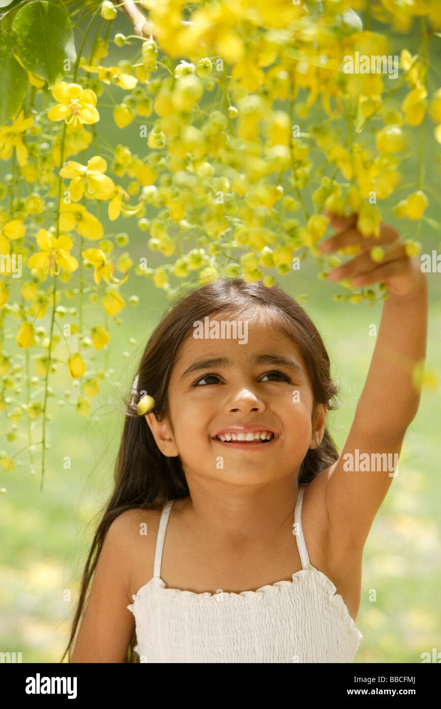 Petite fille en vertu de l'arbre en fleurs Banque D'Images