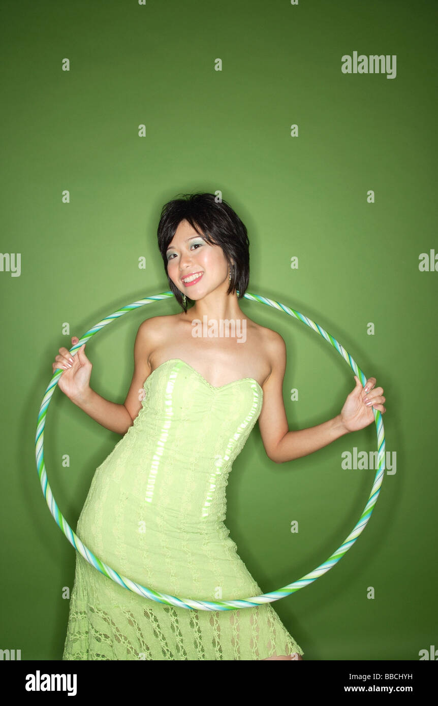 Femme en robe bustier vert, avec hoola hoop Banque D'Images