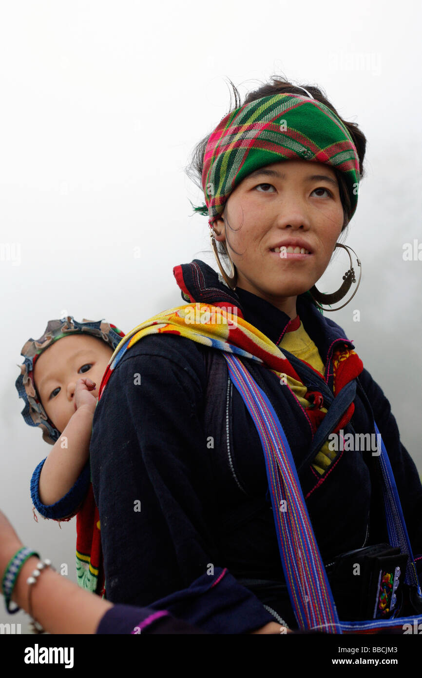 Femme Hmong noir à Sapa avec bébé sur un jour brumeux Banque D'Images