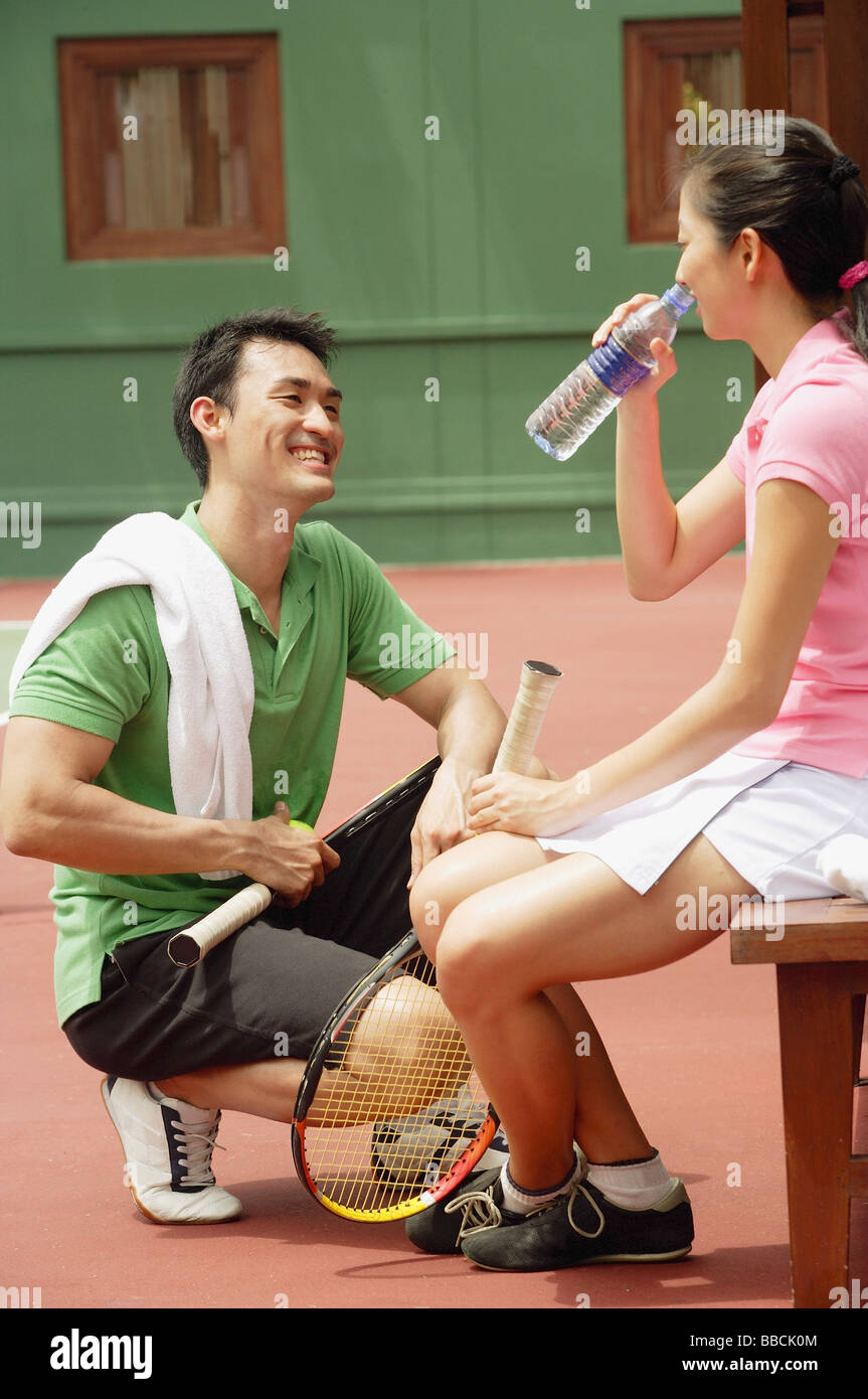 Couple à court de tennis, l'eau potable Banque D'Images