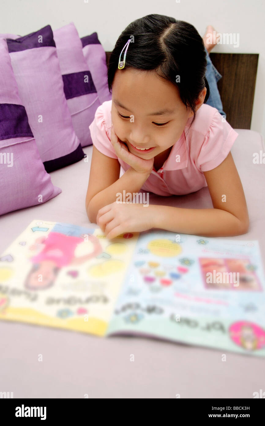 Girl reading magazine, situé sur l'avant Banque D'Images