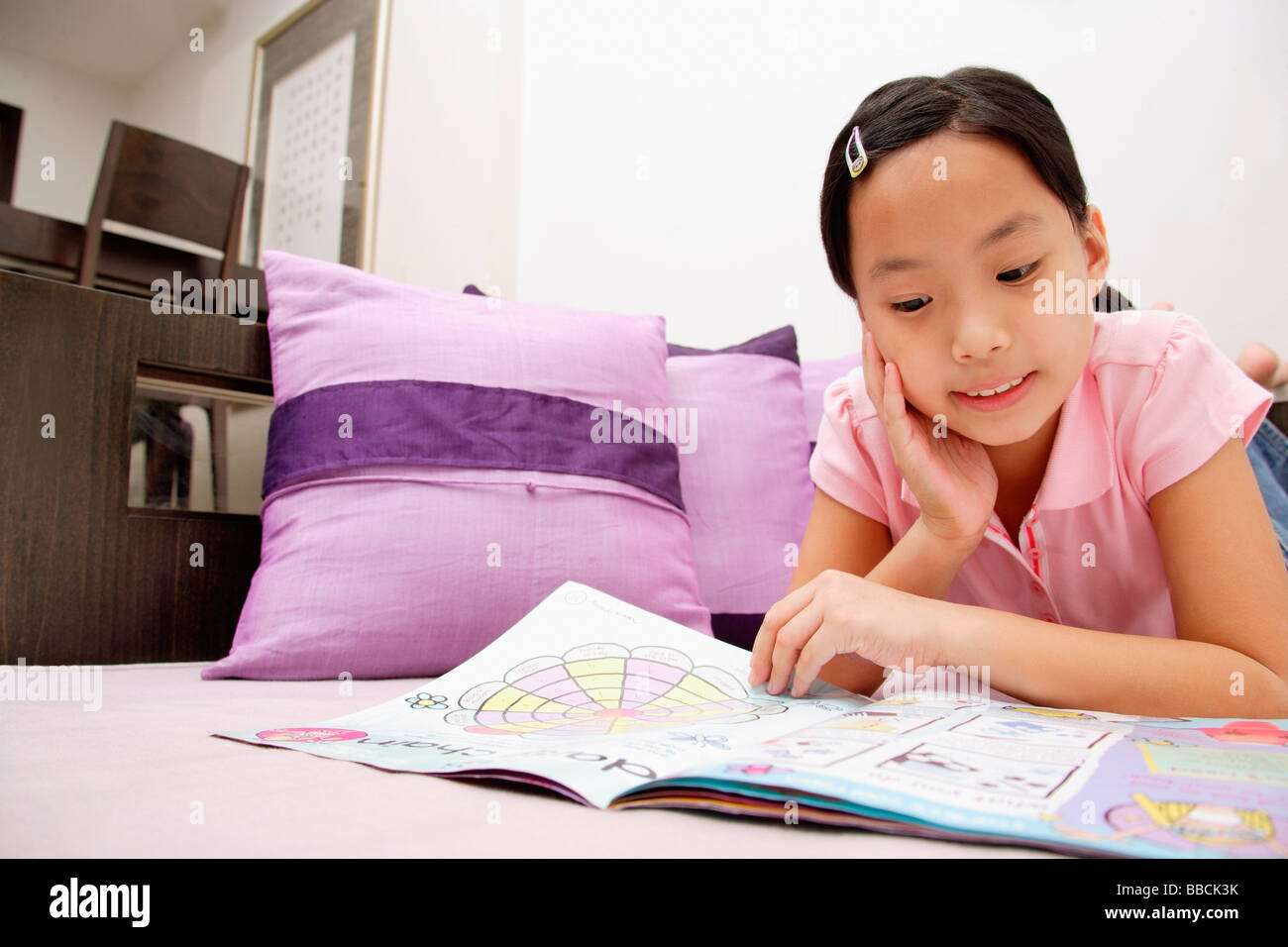 Girl reading magazine, situé sur l'avant, la main sur le menton Banque D'Images