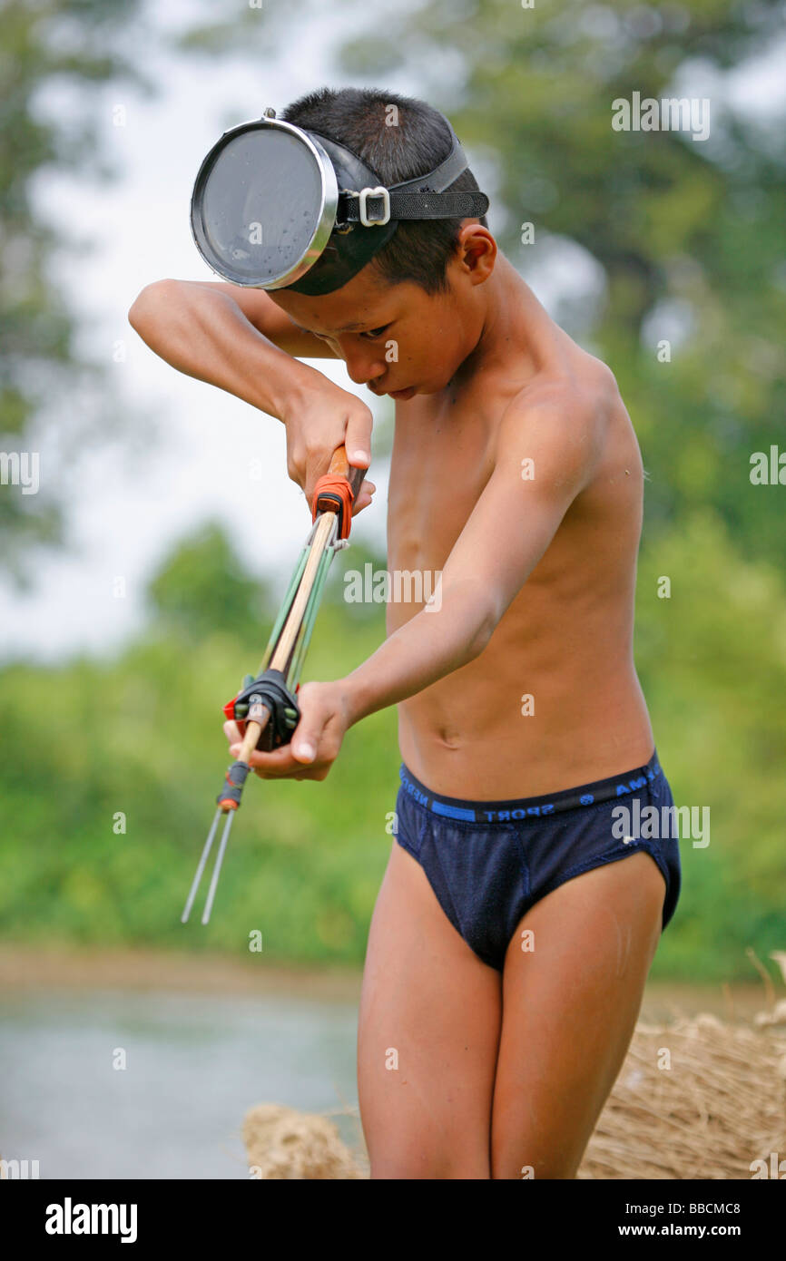 La chasse au petit garçon poisson dans la rivière Nam Song à Vang Vieng, Laos Banque D'Images