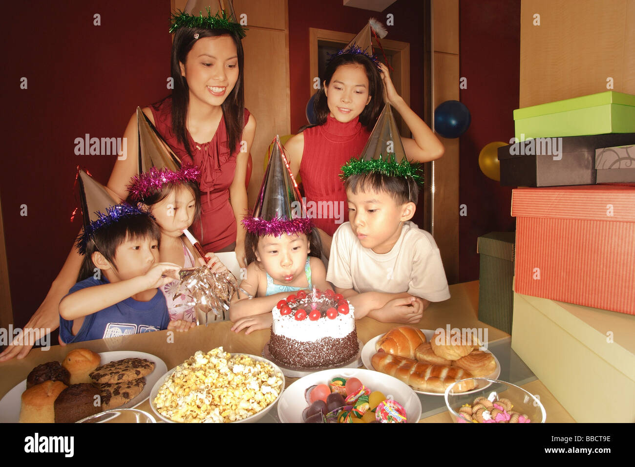 Young Girl blowing out candles at a Birthday party. Banque D'Images