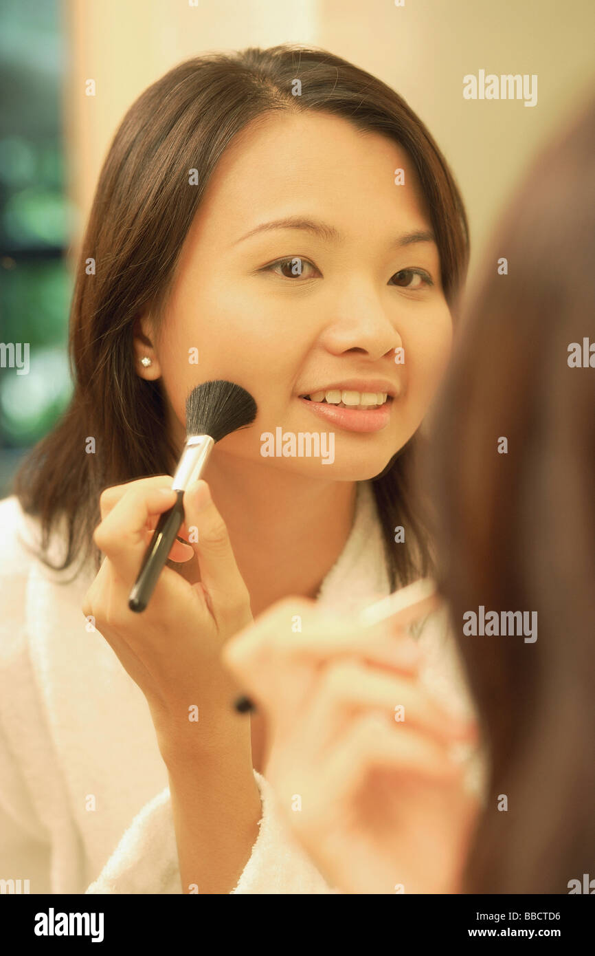 Woman putting on make-up avec un pinceau blush Banque D'Images