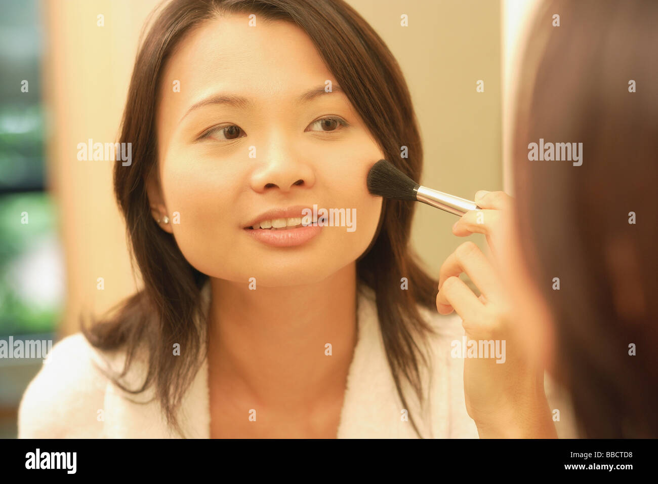 Woman putting on make-up avec un pinceau blush Banque D'Images