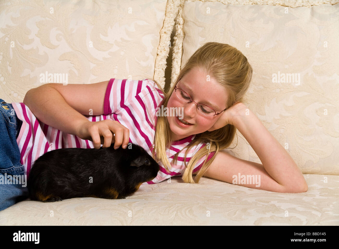 Young Caucasian 10-11 ans ans girl holding sa Myrleen cobaye MR © Pearson Banque D'Images