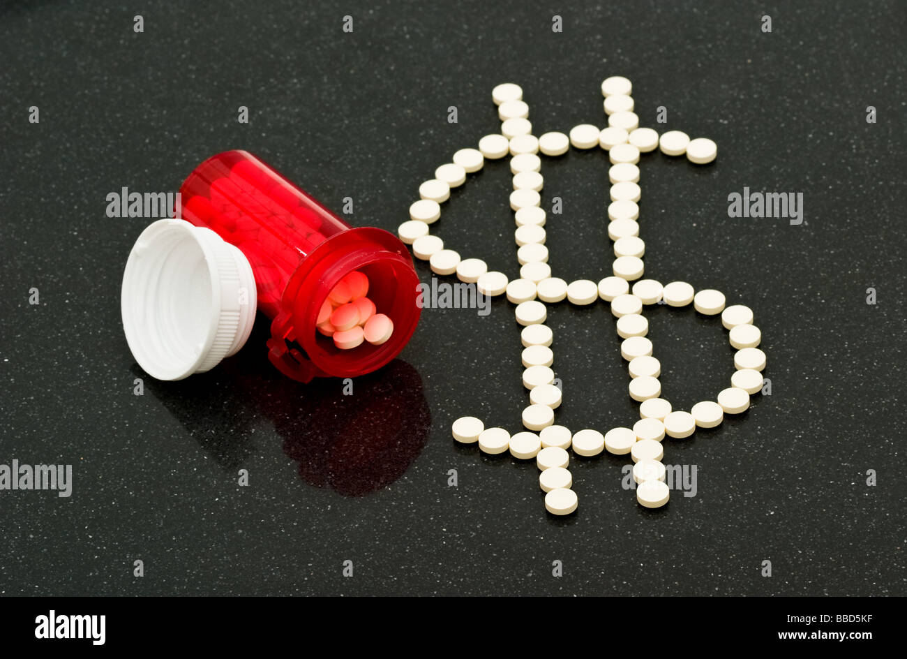 Les petites pilules blanches en forme d'un signe dollar à côté d'une bouteille d'ordonnance rouge et le chapeau partiellement rempli de comprimés Banque D'Images