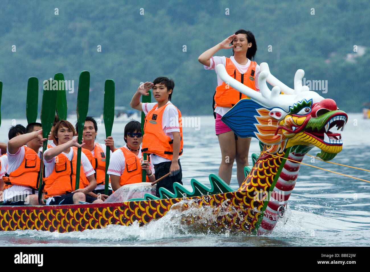 Les rameurs, le batteur et le capteur de drapeau saluent les spectateurs après la course, vus pendant le festival des bateaux-dragons au lac Liyu ou au lac Carp, Hualien, Taïwan Banque D'Images