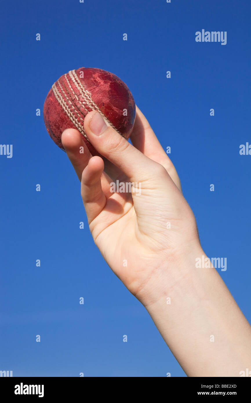 Close up of hand bowling un cricket ball avec une poignée du quilleur swing Banque D'Images
