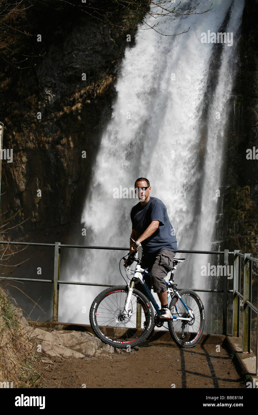 L'équilibrage de motards sur son vélo en face de la vue sur la cascade de tonitruantes, Rinquelle Rin Printemps, et Seerenbach, Betl Banque D'Images