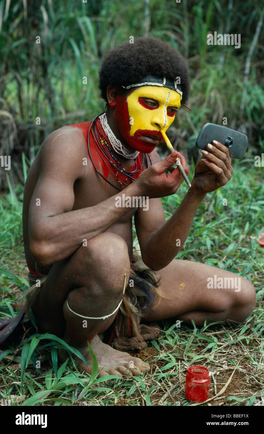La Papouasie-Nouvelle-Guinée en Asie du sud-est des Southern Highlands Tari Valley Huli tribu du visage à l'aide de peinture ancienne wing mirror pour voir Banque D'Images