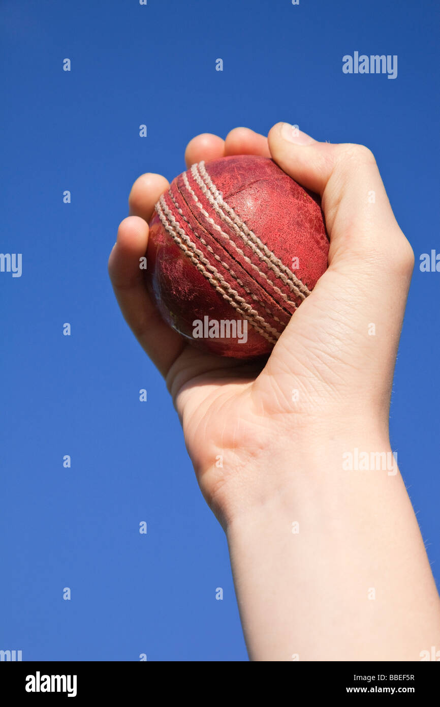 Cricket ball attraper la main contre un ciel bleu Banque D'Images