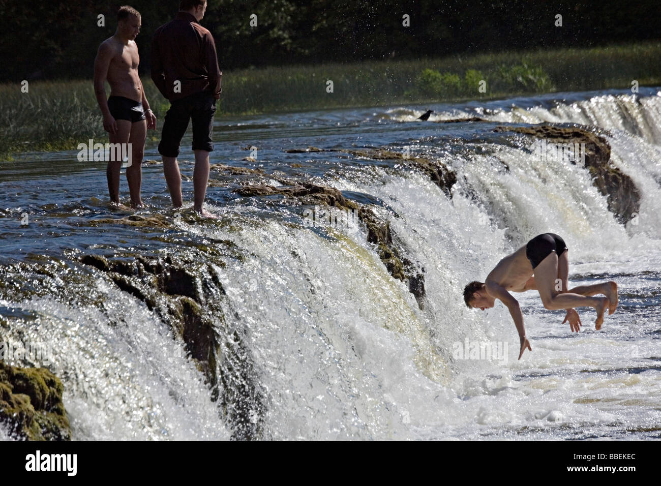 Les garçons sautant à Ventas Rumba de cascades à Kuldiga Lettonie Kurzeme ville Banque D'Images