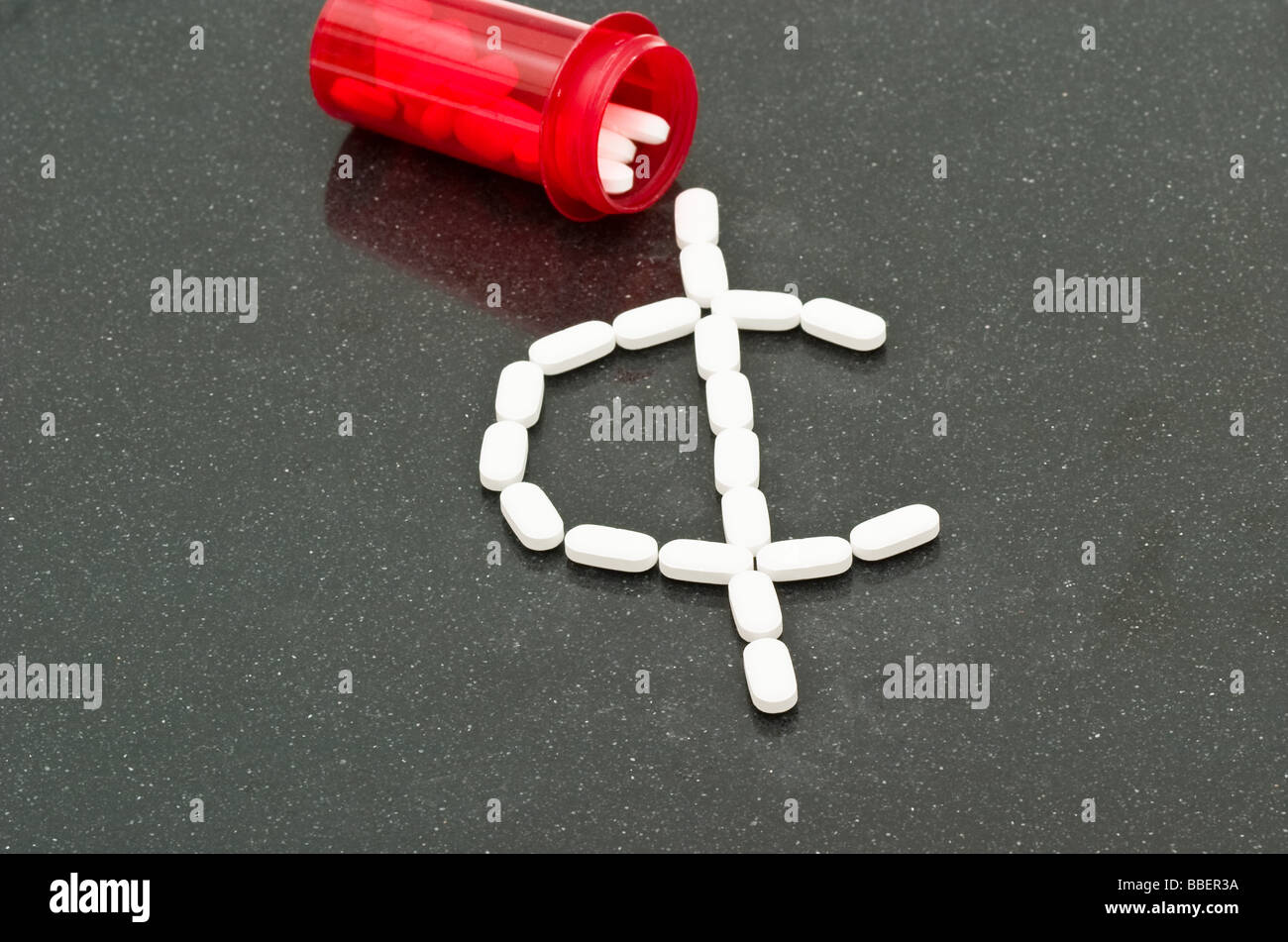 Les petites pilules blanches en forme de c. sign à côté d'une bouteille d'ordonnance rouge partiellement rempli de comprimés Banque D'Images
