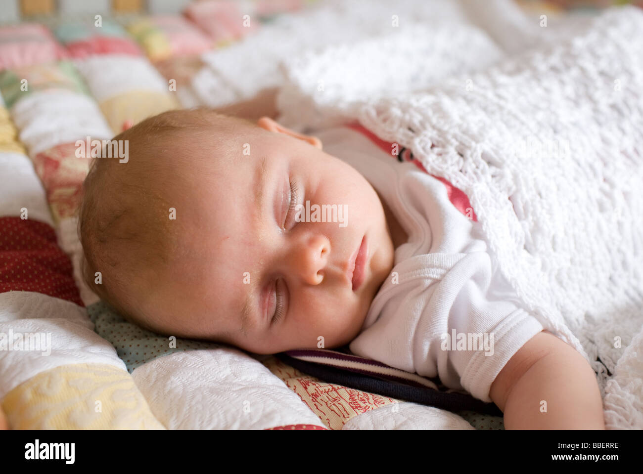 Baby Girl sleeping en berceau sur quilt avec couverture en crochet blanc. Toronto, Ontario Banque D'Images