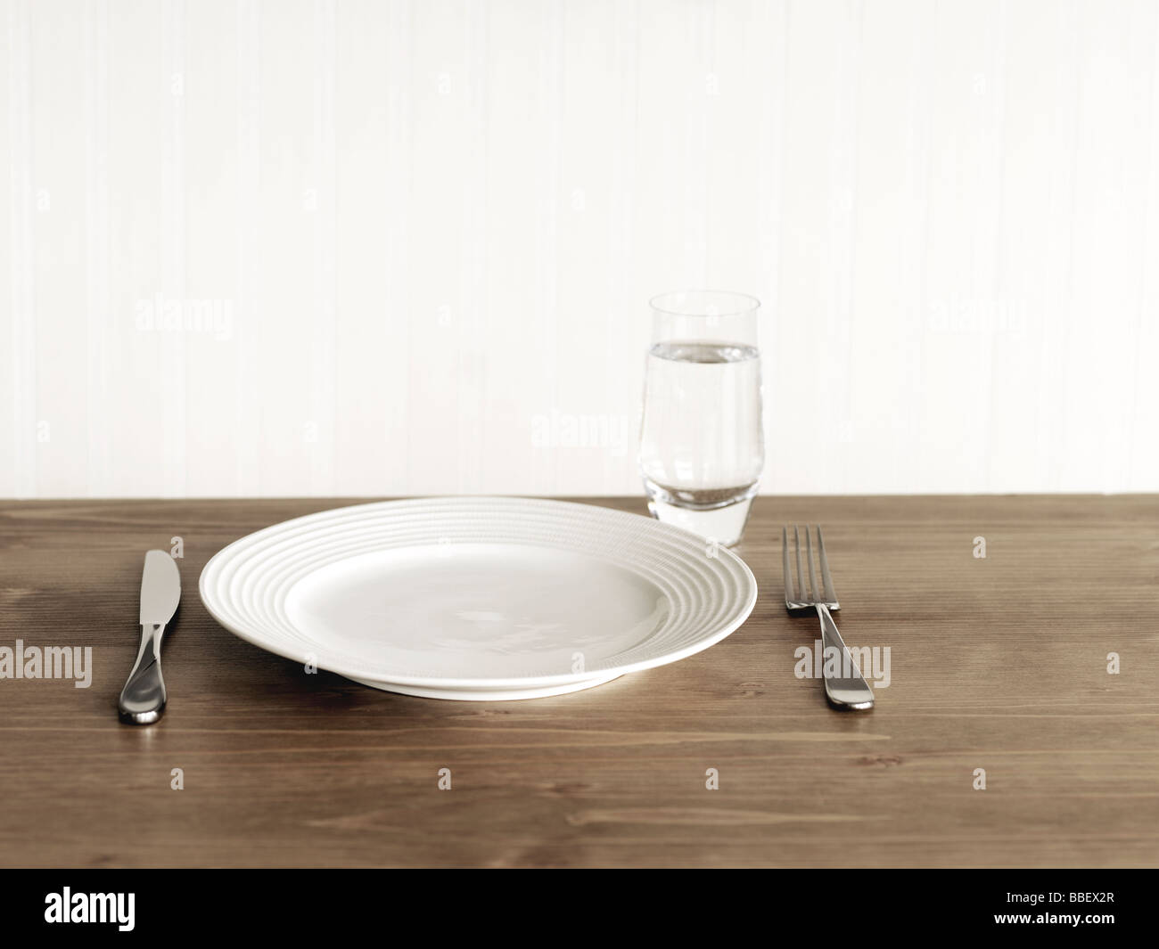 Place avec une assiette, couteau, fourchette et un verre d'eau Photo Stock  - Alamy
