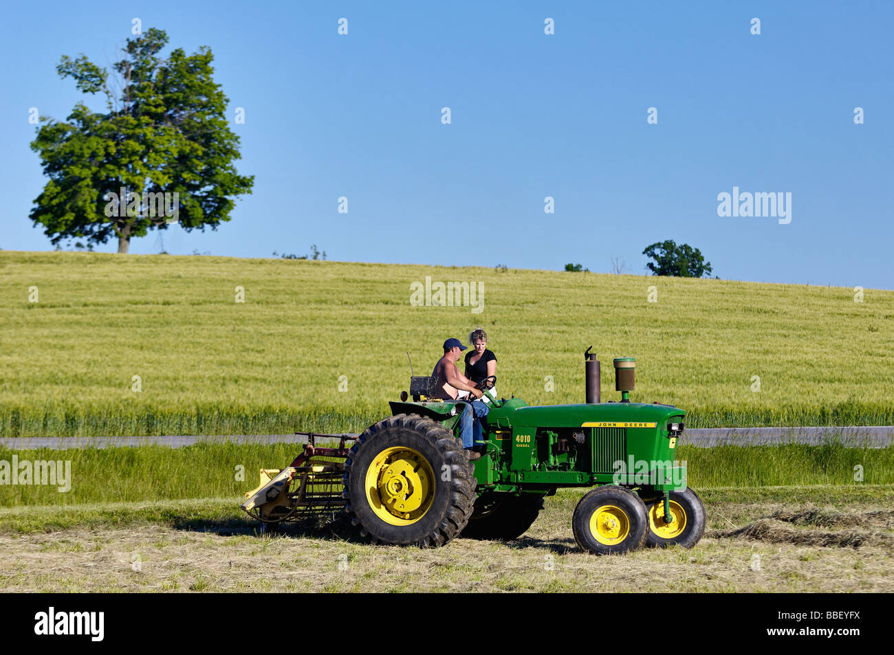 Fermier et sa femme sur John Deere 3010 Tracteur diesel dans la région de Harrison County Indiana Banque D'Images