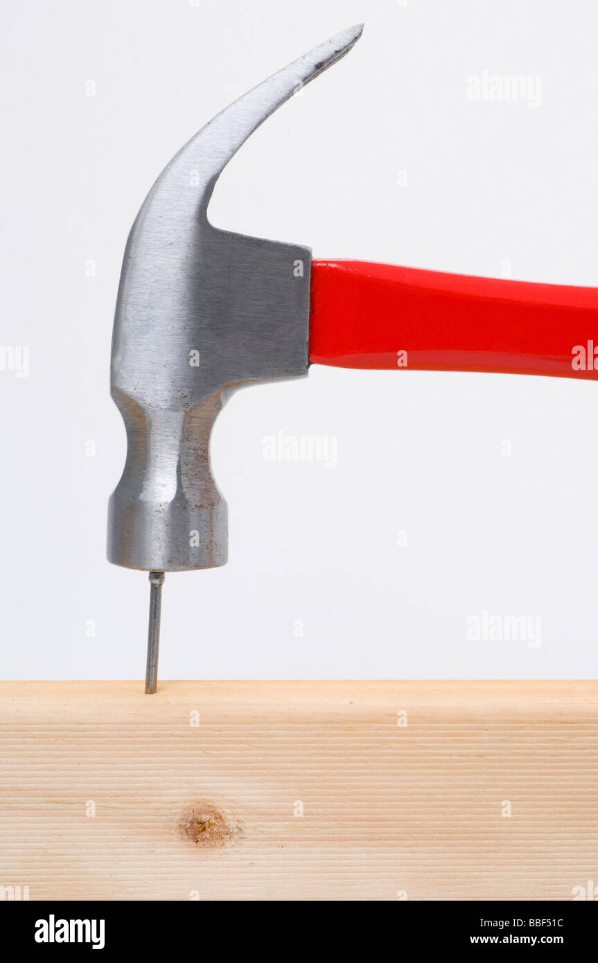 Hammer hitting un clou sur la tête en bois Banque D'Images