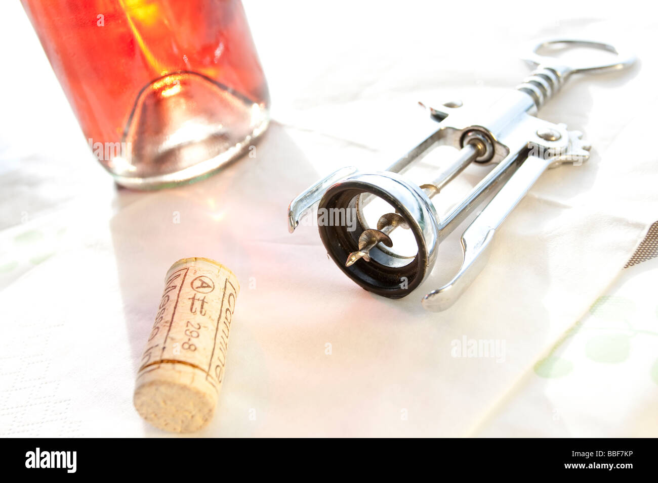 Bouteille de vin, tire-bouchon et liège sur une table lumineuse Banque D'Images