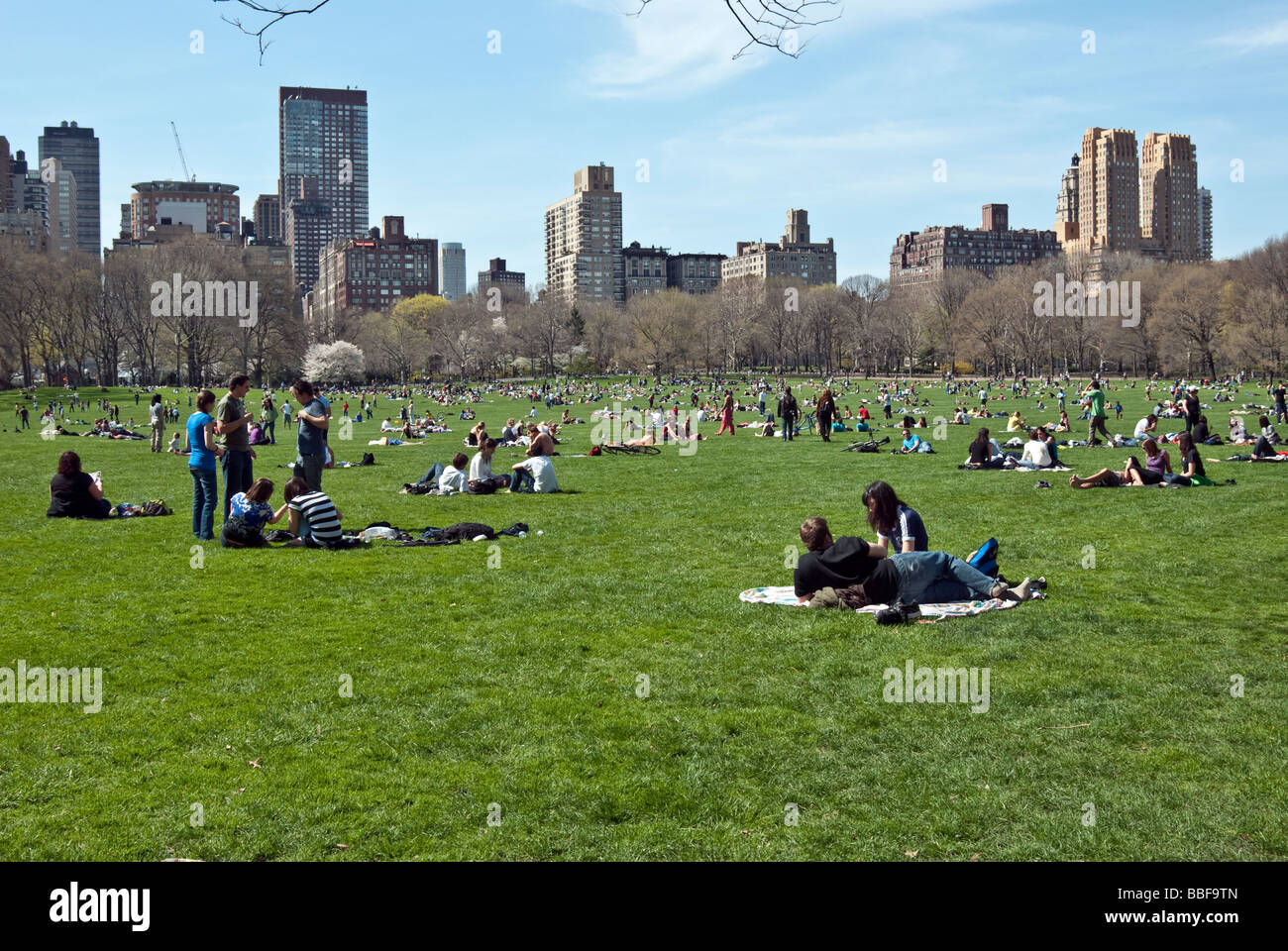 Une foule de jeunes répartis dans l'herbe de Central Park Moutons pré sur un week-end de printemps à New York City Banque D'Images