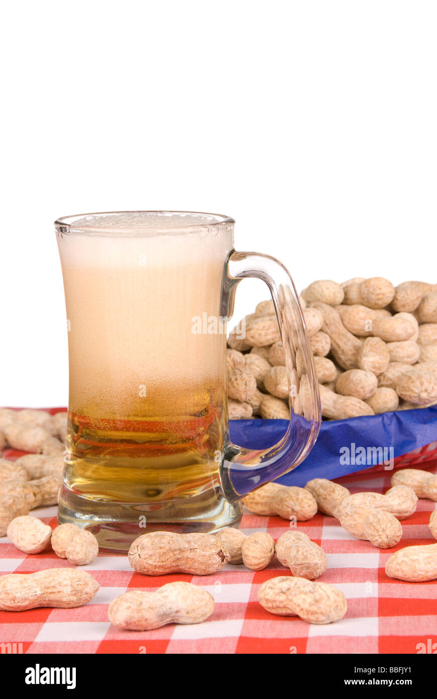 Une chope de bière froide entouré par circus arachides fond blanc gauche pour copy space Banque D'Images