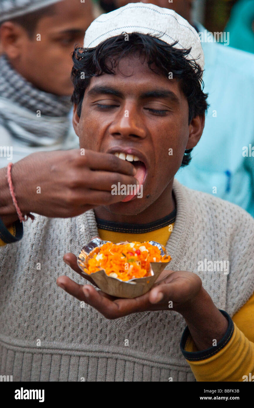Jeune Musulman de manger au Hazrat Nizamuddin Dargah sanctuaire musulman dans Old Delhi Inde Banque D'Images