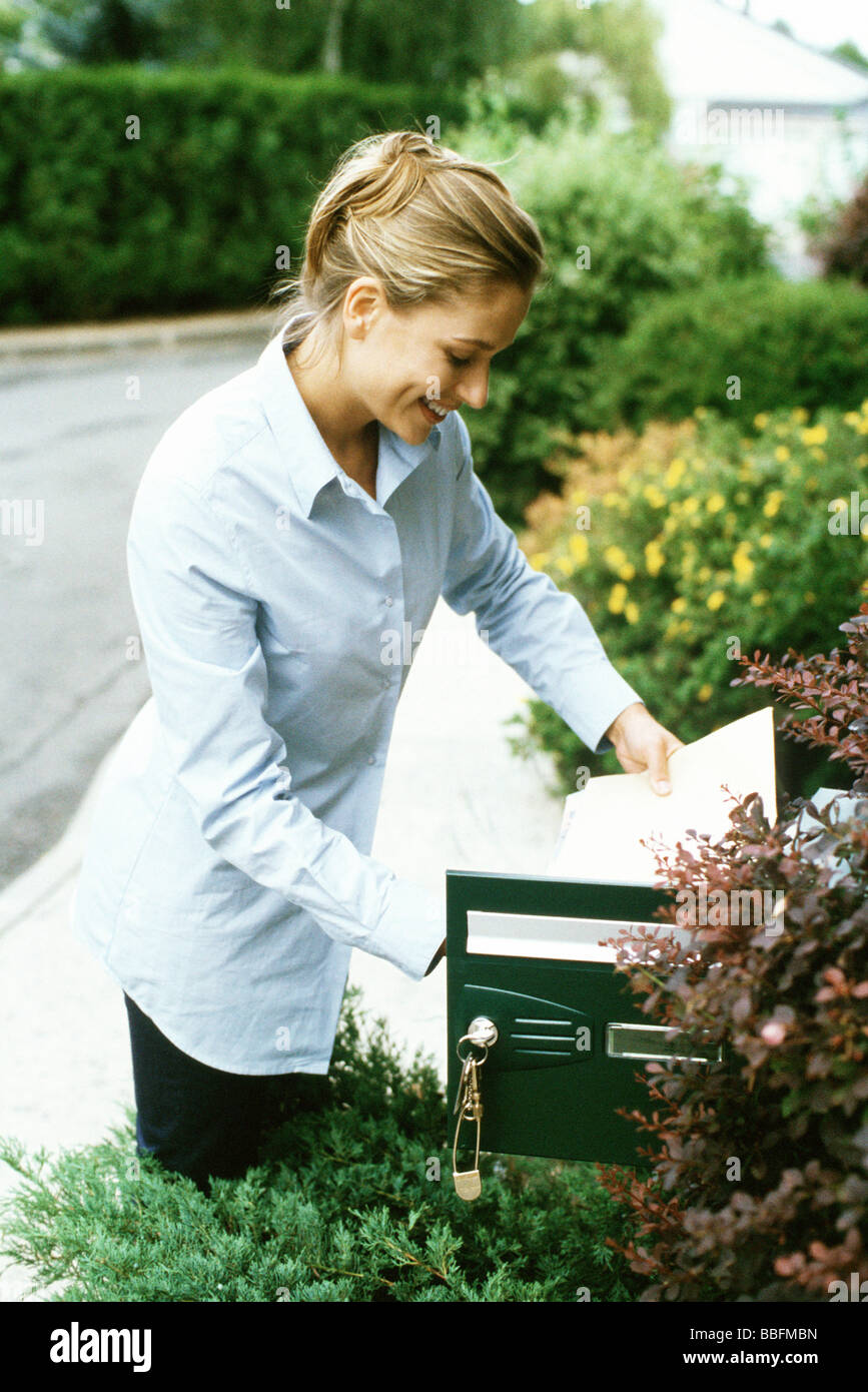 Woman checking mail, smiling Banque D'Images
