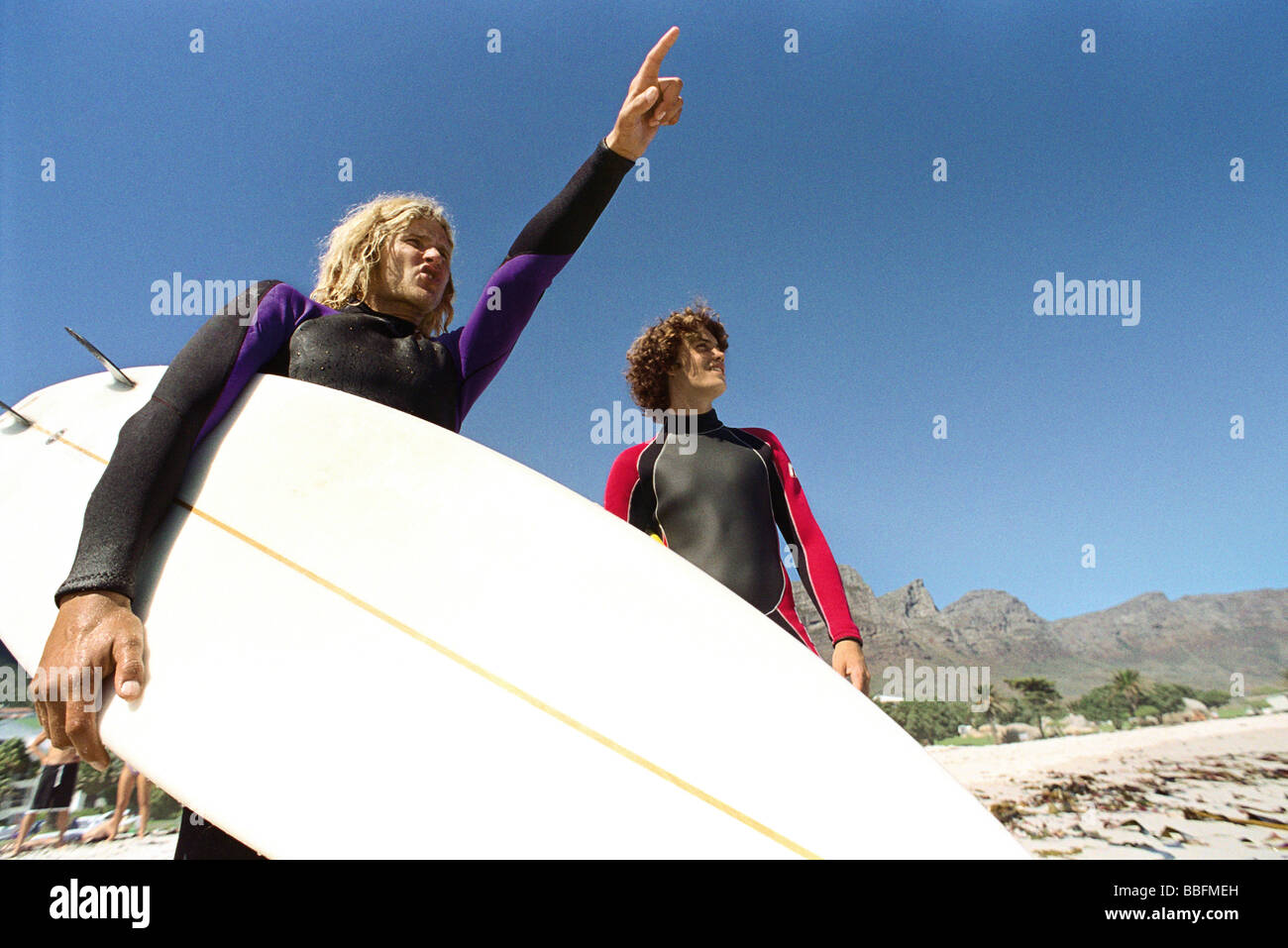 Les surfeurs sur la plage, l'une dirigée à distance Banque D'Images