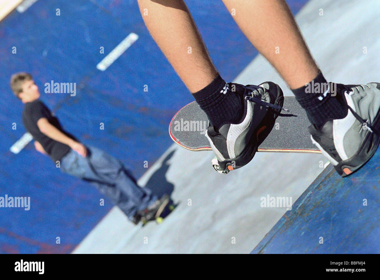 La planche de bord perché à regarder la rampe sur rampe de skate ami  ci-dessous Photo Stock - Alamy