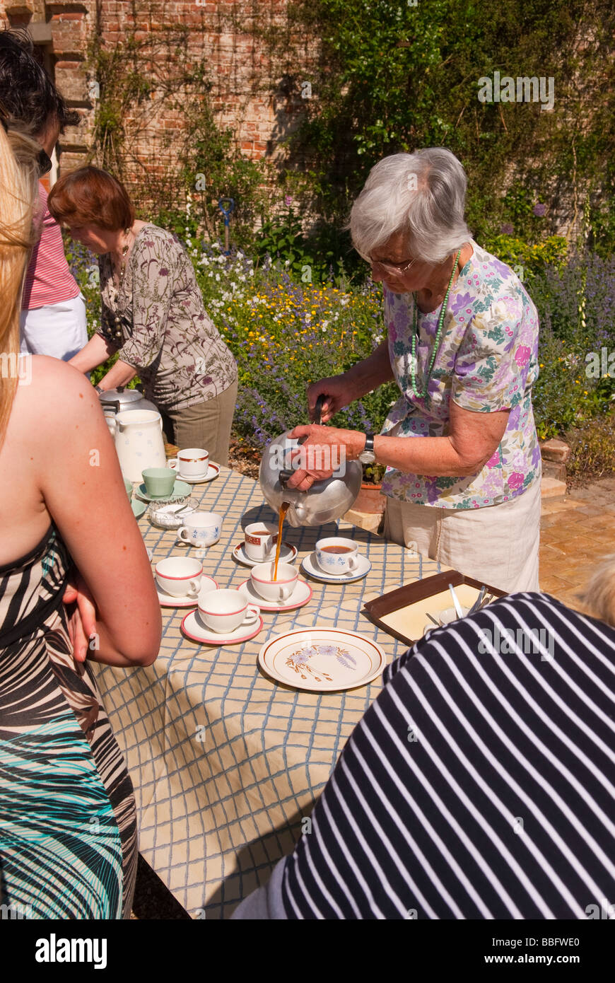 Les visiteurs ayant des rafraîchissements dans un jardin ouvert à un événement uk country house au printemps Banque D'Images