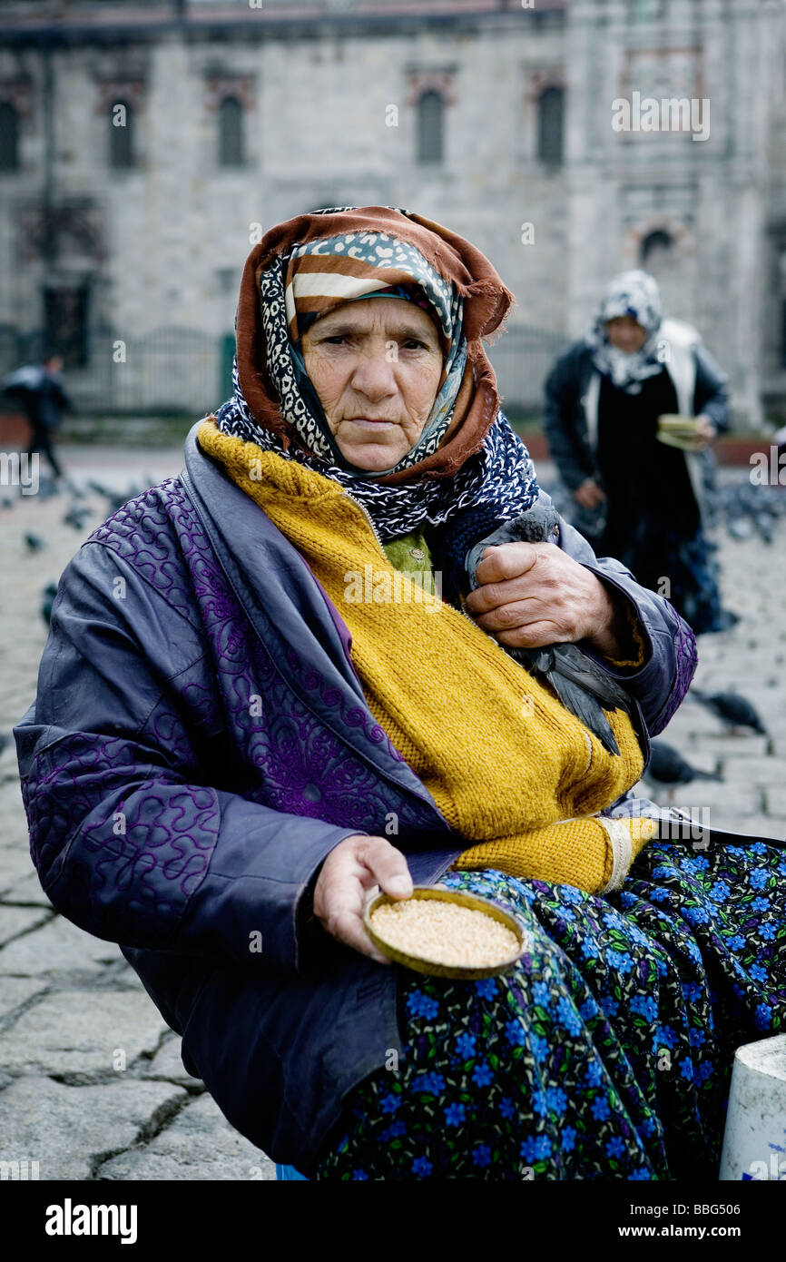 Vieille Femme vendant des aliments pour oiseaux près d'une mosquée. Istanbul, Turquie. Banque D'Images