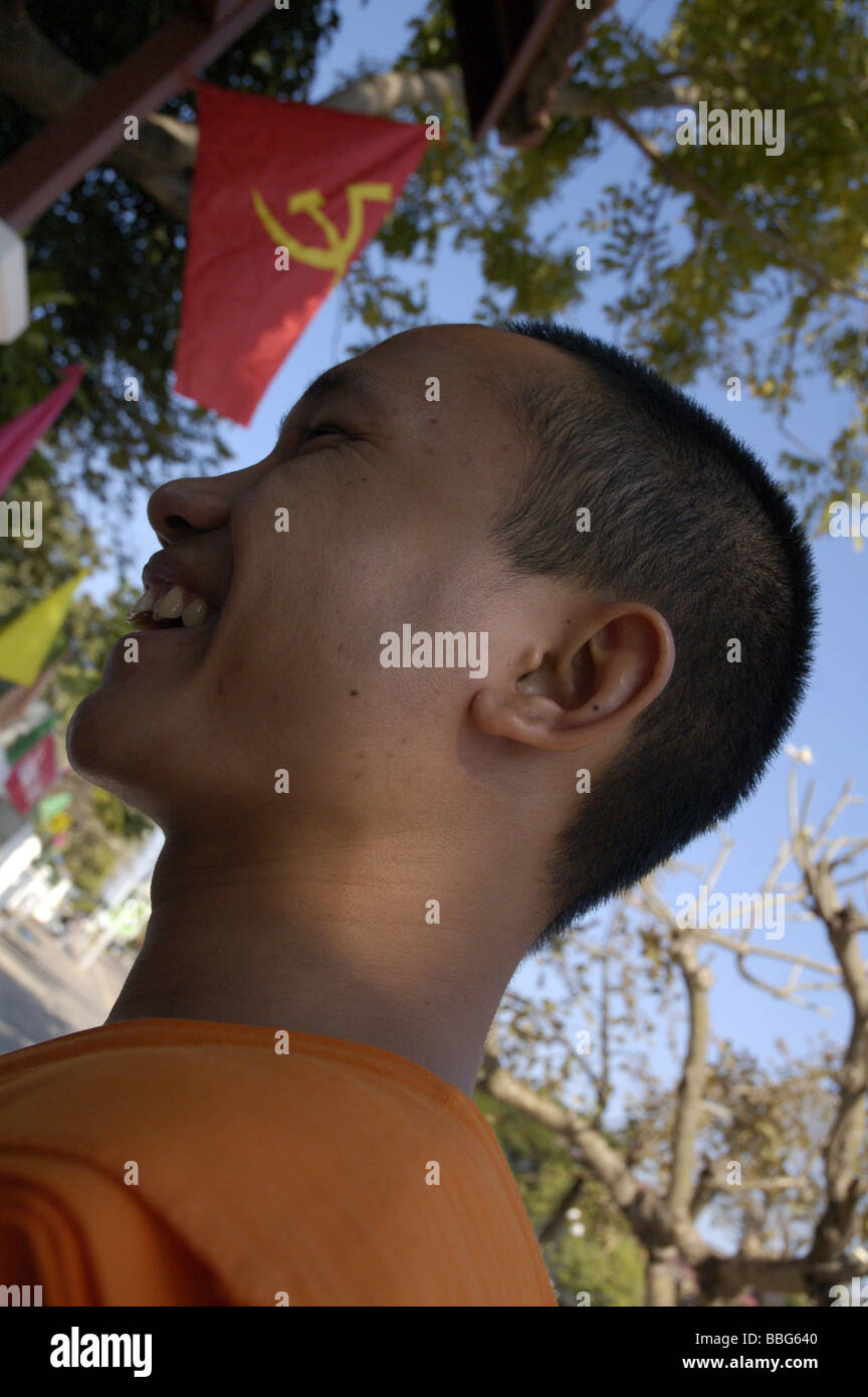 Le moine bouddhiste avec drapeau communiste à Vientiane, Laos Banque D'Images