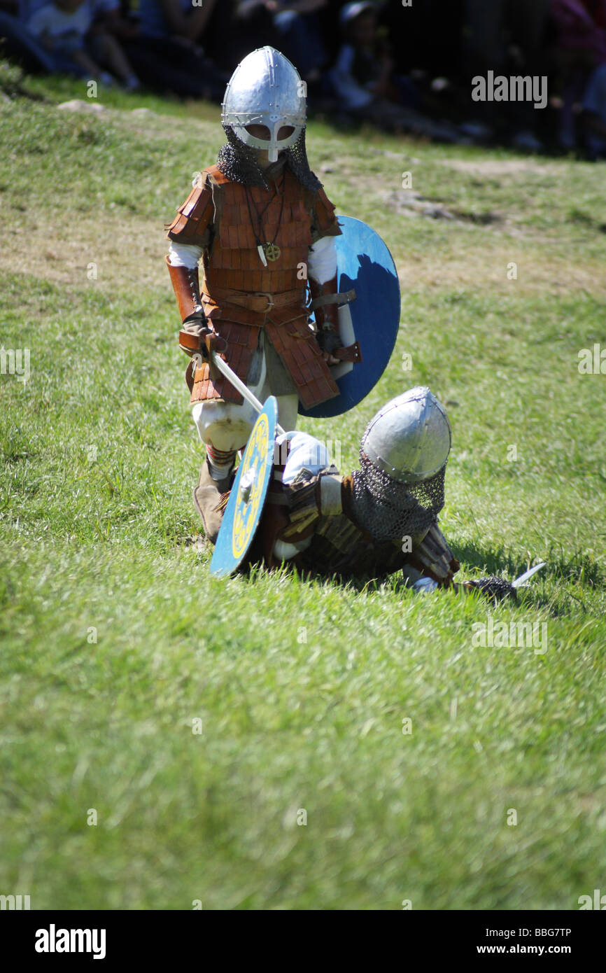 Les enfants jouent lutte avec des épées au cours de la promulgation d'une bataille médiévale au Château Ogrodzieniec, Pologne. Banque D'Images