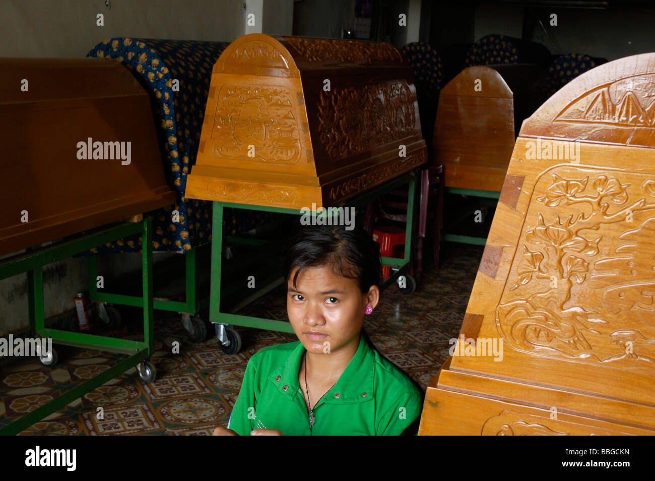 Un Cambodgien Chinois mixte-fille dans sa boutique qui vend des cercueils dans le centre de Phnom Penh, Cambodge Banque D'Images