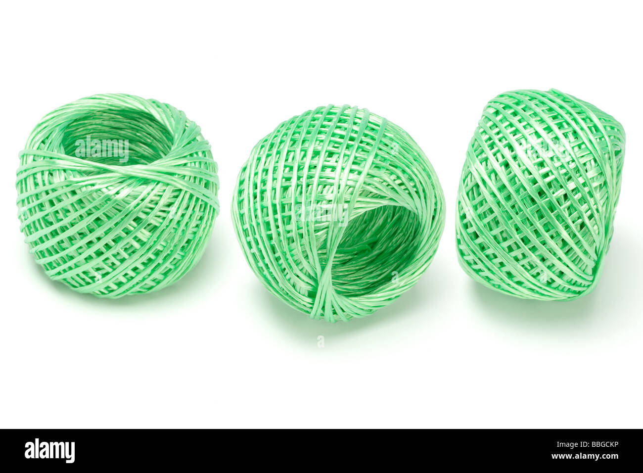 Trois boules de cordes de nylon vert organisé sur fond blanc Banque D'Images