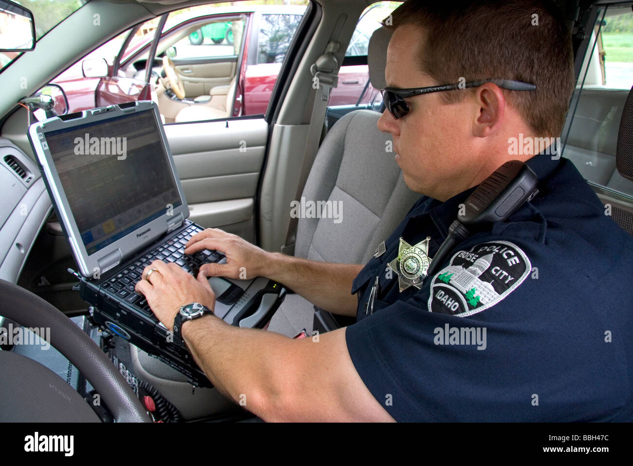Agent de police à l'aide d'un terminal de données mobiles à l'intérieur d'une voiture de police dans la région de Boise IDAHO USA Banque D'Images