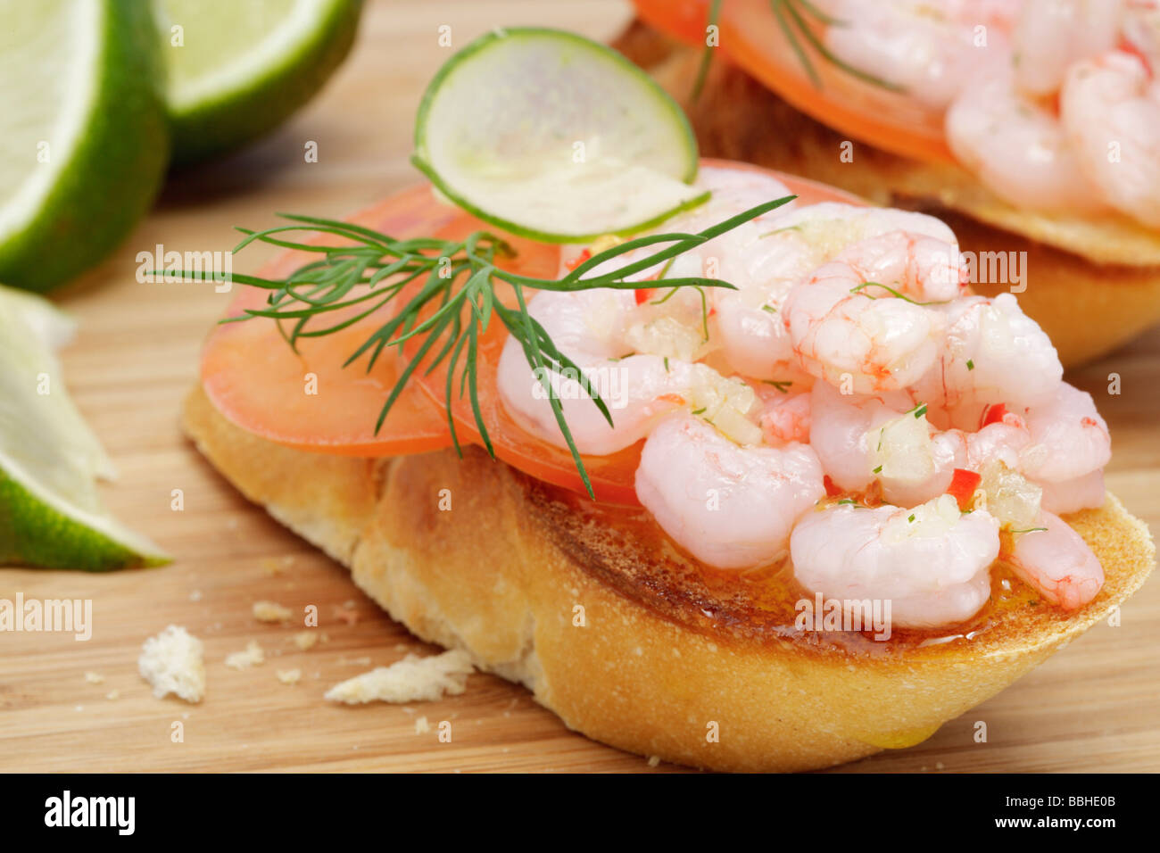 Crostini à la tomate et salade de crevettes, citron vert brun Banque D'Images