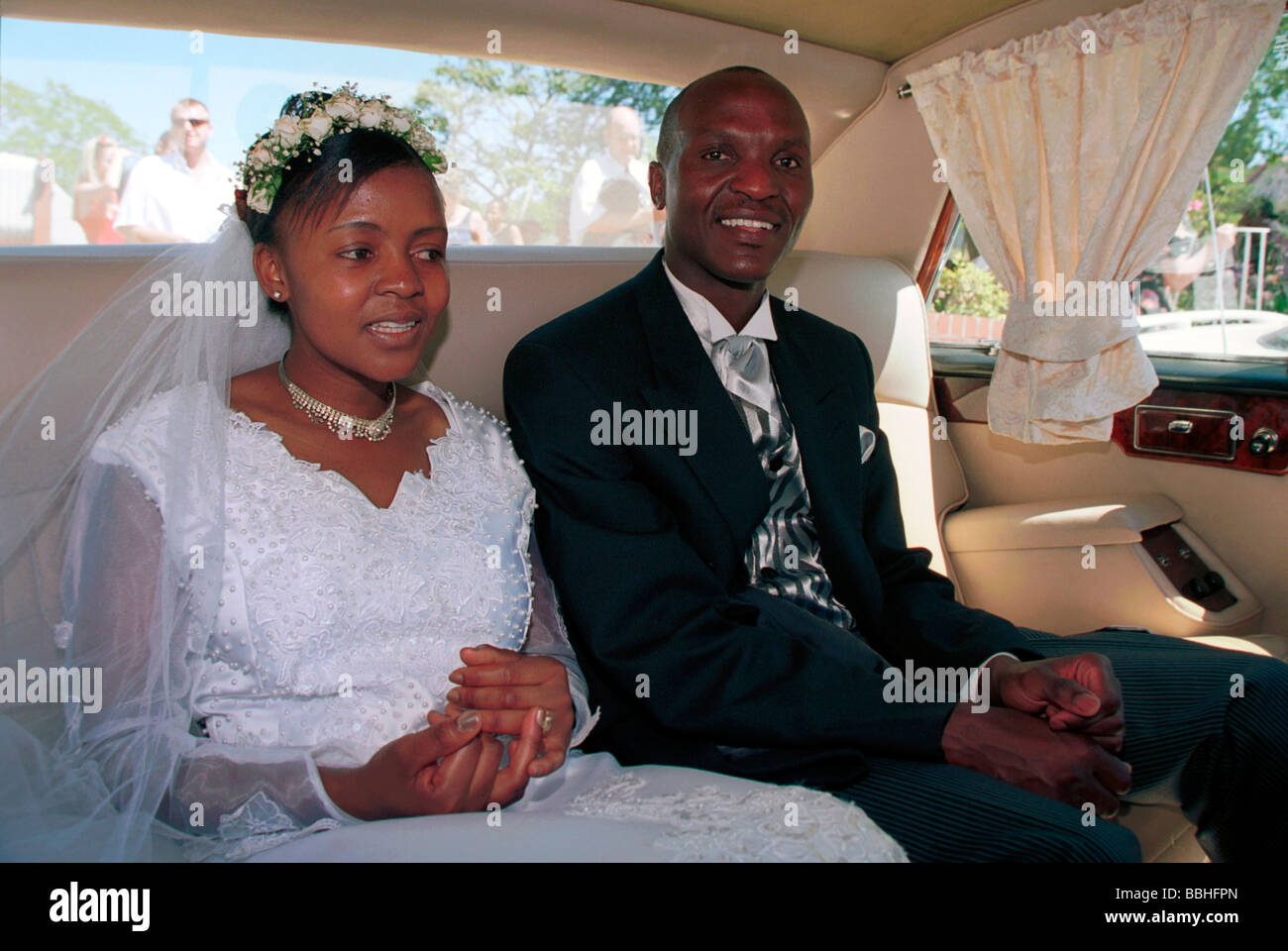 Avec plaisir évident Listien Mchunu rejoint sa nouvelle femme sur le siège arrière de la Daimler avec chauffeur à la fin du service Banque D'Images