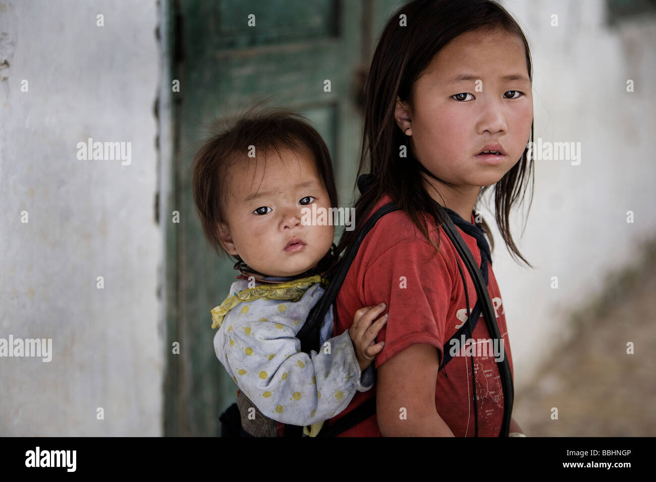 Sapa, Vietnam ; les enfants plus âgés sont souvent des aidants naturels principaux de leurs frères et sœurs plus jeunes et de les transporter sur leur dos Banque D'Images