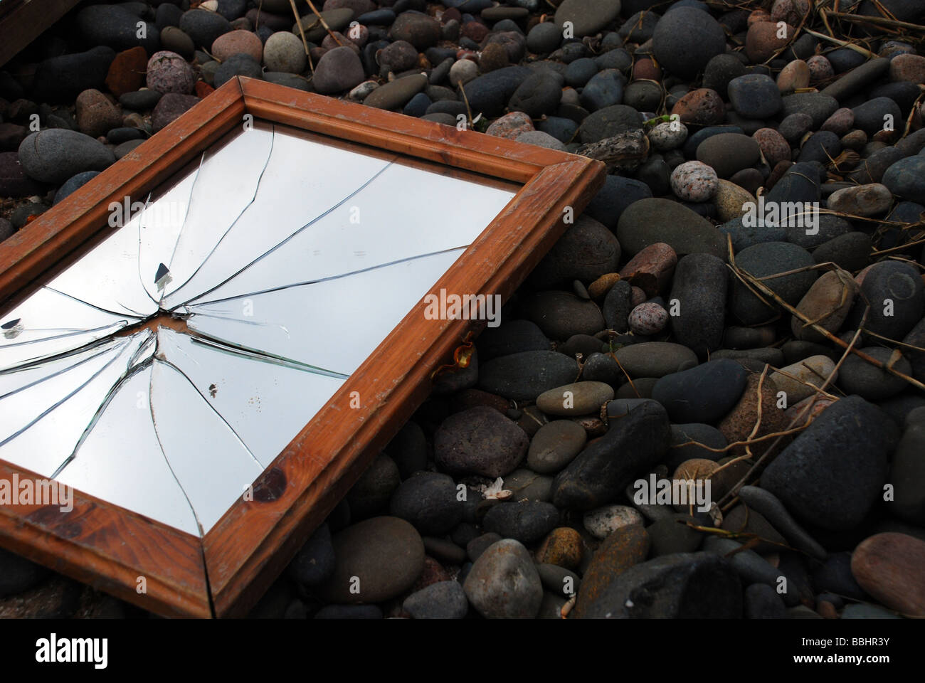 Miroir cassé sur une plage de galets Banque D'Images