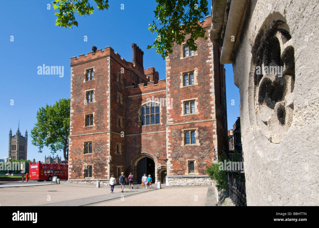 Façade Tudor et châtelet d'entrée à Lambeth Palace avec les Chambres du Parlement et du bus touristique Lambeth derrière London UK Banque D'Images