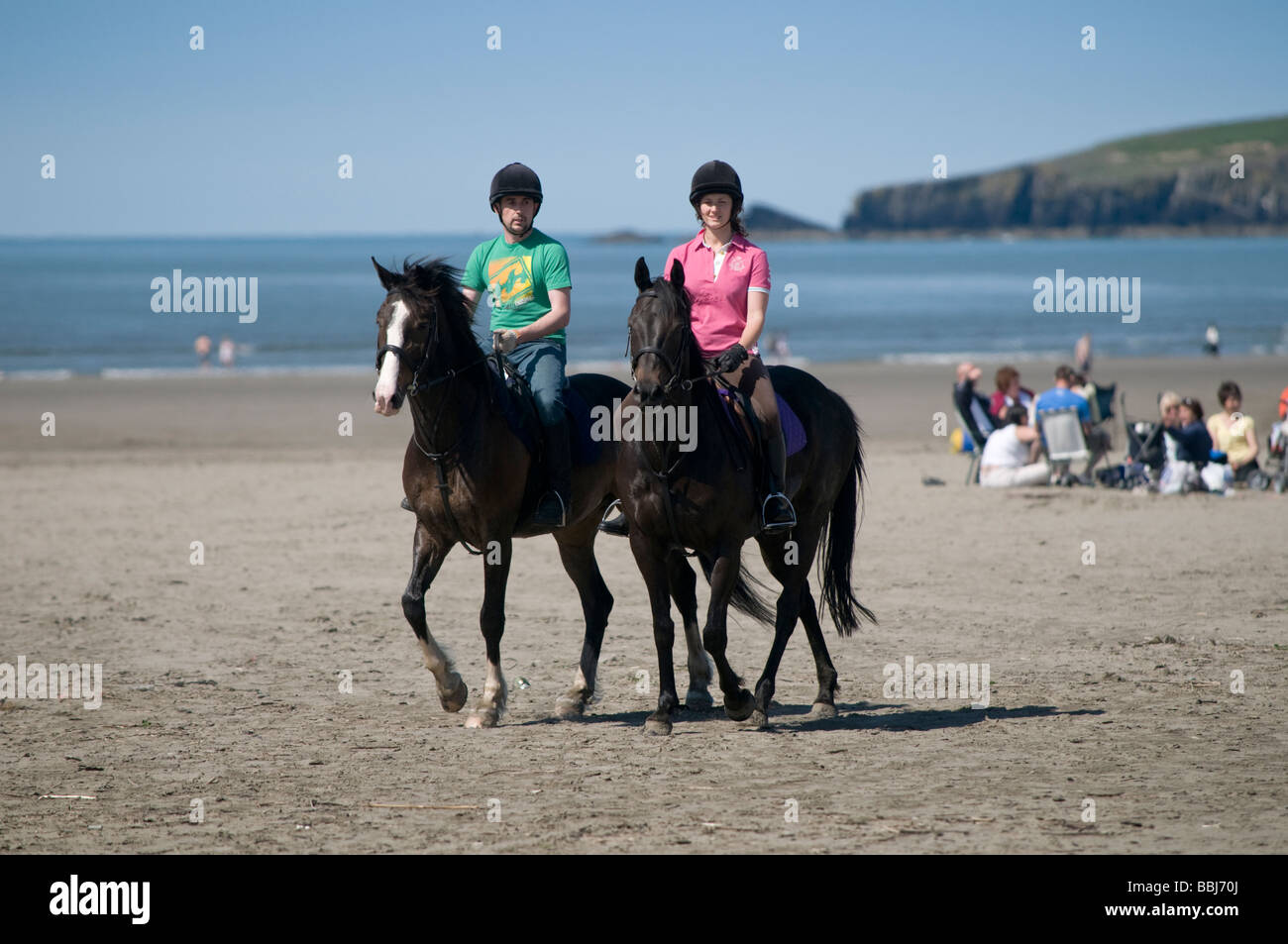 Après-midi d'été ensoleillé - un couple de l'équitation sur Poppit Sands Pembrokeshire Coast national park plage Wales UK Banque D'Images