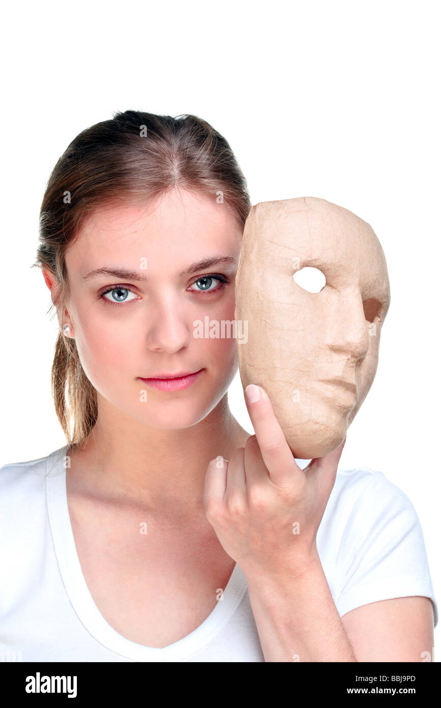 Jeune femme tenant un masque devant son visage isolé sur fond blanc Banque D'Images