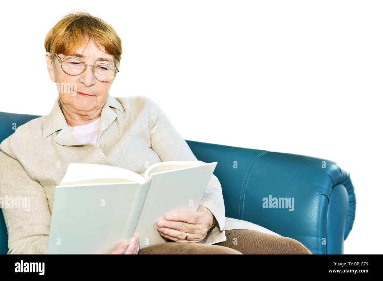 Woman relaxing on couch reading a book Banque D'Images