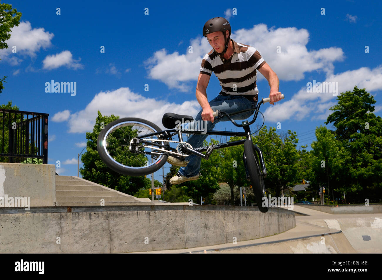 Biker bmx volant au-dessus d'un bol, faire un 360 tailwhip at an outdoor skate park à toronto Banque D'Images