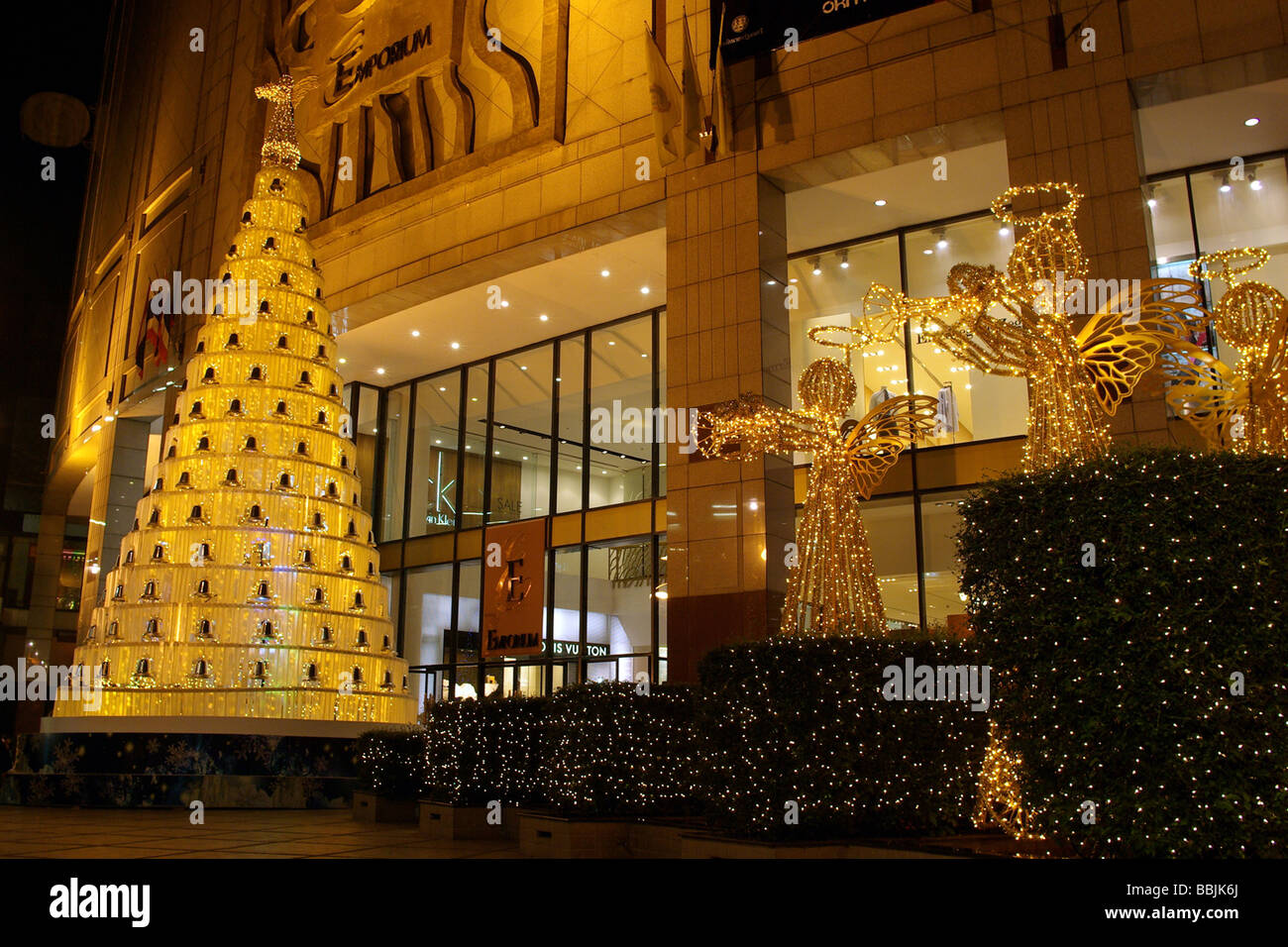 Arbre de Noël et de l'allumé d'or anges attirer l'attention sur la façade de l'Emporium shopping mall à Bangkok en Thaïlande. Banque D'Images