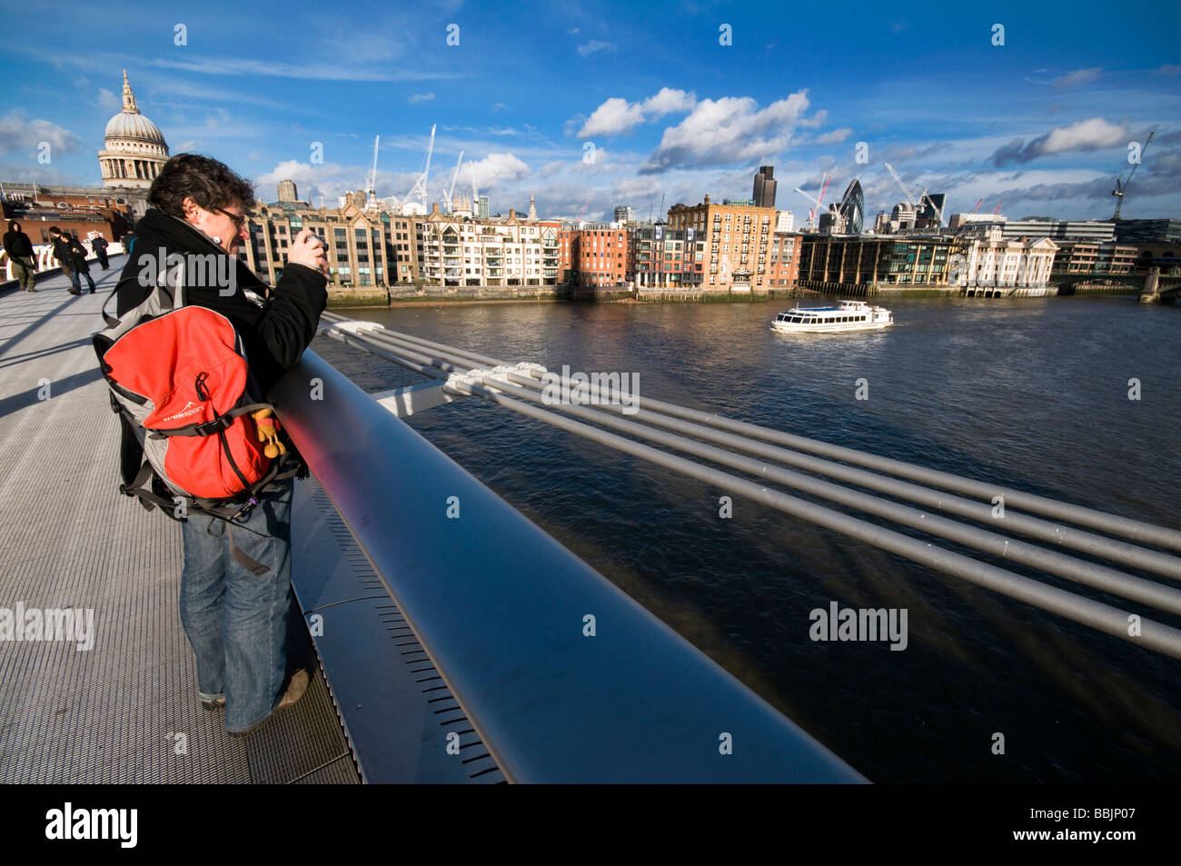 Un touriste en prenant des photos sur Millennium Bridge, London, UK Banque D'Images