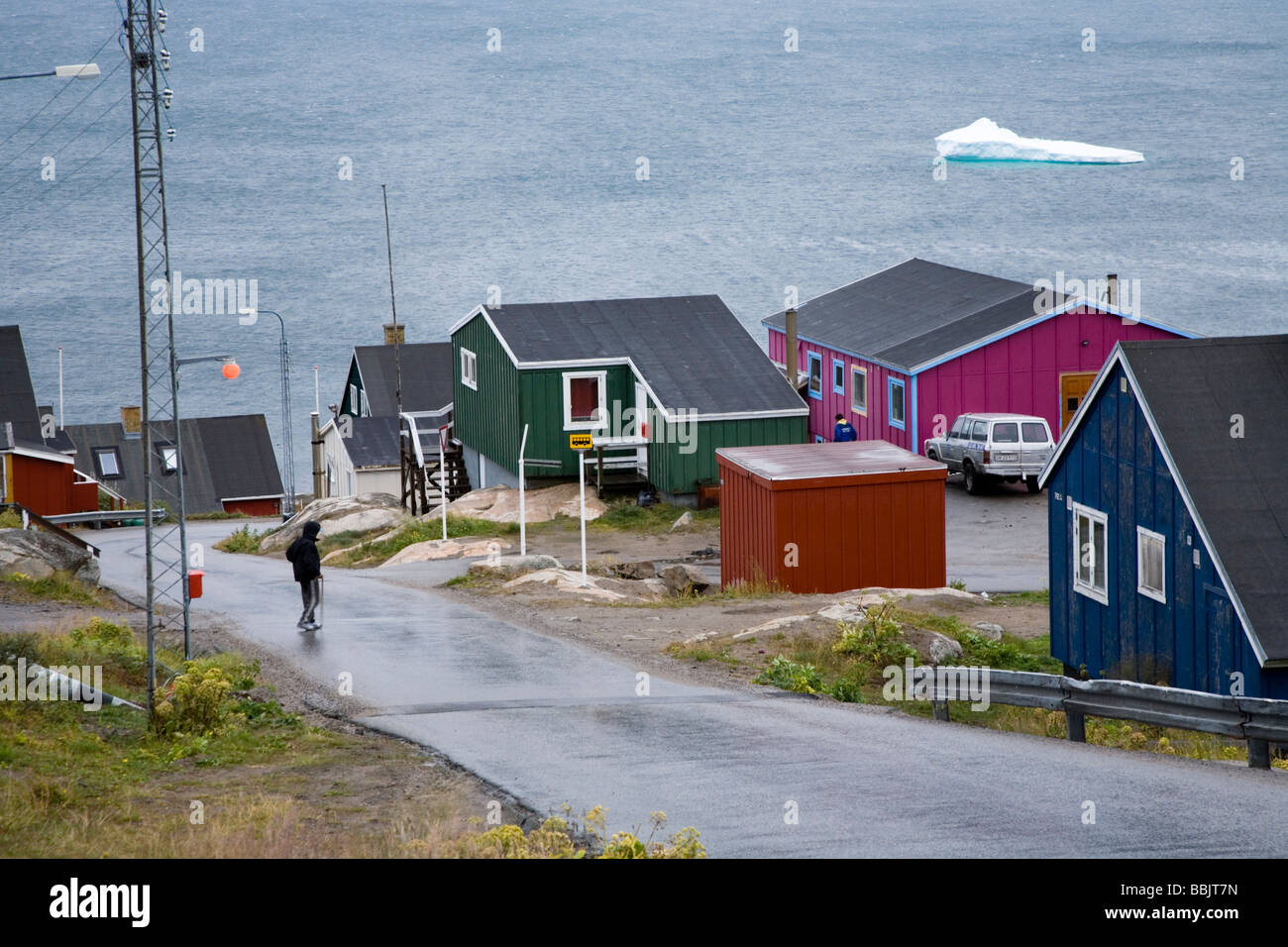 L'homme de traverser la rue, maisons colorées et d'iceberg. Qaqortoq (Julianehåb), le sud du Groenland Banque D'Images